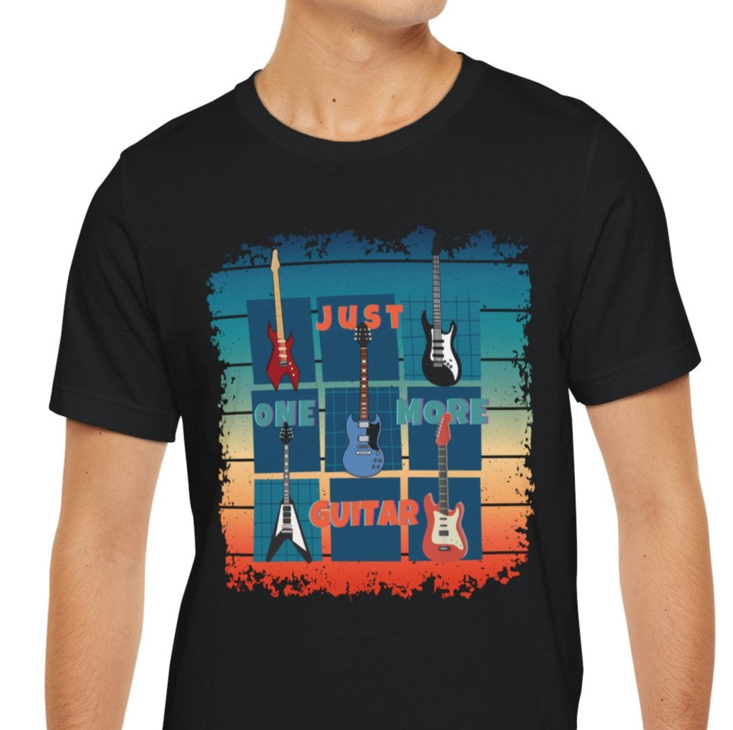 A person wearing a black short-sleeved T-shirt with a colorful graphic design that includes the text 'Just One More Guitar' and images of guitars.