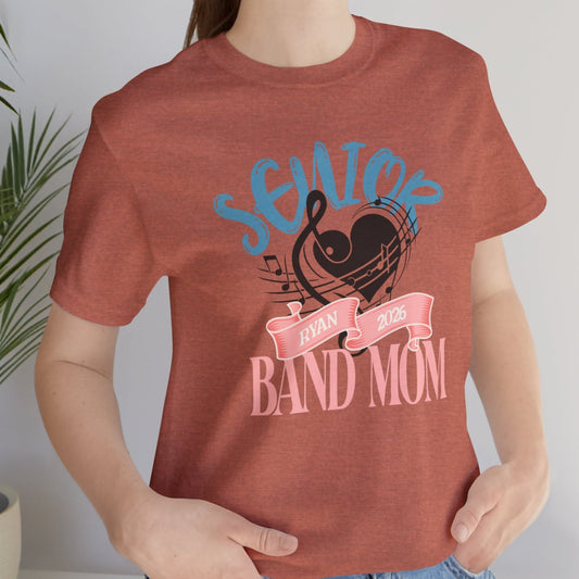 Person wearing a red t-shirt with 'Senior Band Mom' design, standing indoors.